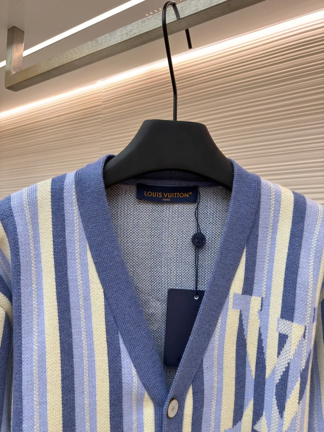 LOUIS VUITTON striped jacquard single-breasted sweater ●Original version: Purchased and developed for 15100 ●Item number: 1682314-C00 ●Fabric: wool fabric ●Technology: jacquard knitting ●Color: blue ●Version: fitted version ●Weight: about 930 grams ●Size: S-M-L-XL ●Description: This LV striped knitted cardigan is made of high-count worsted wool blended yarn. The double-ply threading process enhances the yarn's toughness. It is not easy to pill and has an outstanding drape feeling. The body of the garment adopts vertical jacquard weaving technology, with navy blue, light blue and off-white yarns interlaced with each other. The stripe width and spacing are precisely controlled by a computerized flat knitting machine, so that the color transition is natural and even. The LV letter jacquard on the left body has been debugged several times through plate making to ensure that the pattern is three-dimensional and clear. The V-neck, cuffs, and hem all use ribbing technology and are pre-shrunk to shape, making them less likely to loosen and deform after long-term wear. The buttons are made of custom-made metal, with matte sandblasting on the surface, and are hand-stitched with the seams of the body. The pockets use welting technology, and the edges are flat without jumpers. Every detail reflects the exquisite clothing craftsmanship and brand ingenuity. The overall wiring is straight and delicate, the fabric is comfortable and soft, and the color is consistent without color difference. It can be matched with the same style to create a fashionable look and control various occasions. Customized accessories, complete with three standards, same style for men and women!